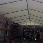 Lagerhalle mit Unterzugsplanen und Rolltor.